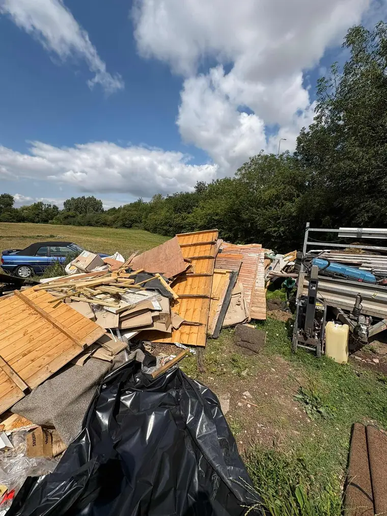 A pile of old fence panels, timber, carpet and cardboard waiting to be cleared